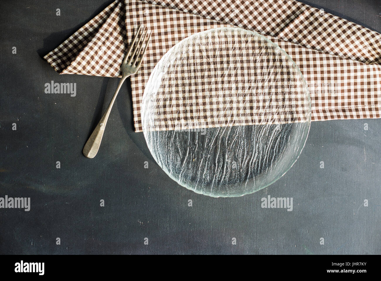 Rustic table setting with empty plate and vintage fork on dark wooden ...