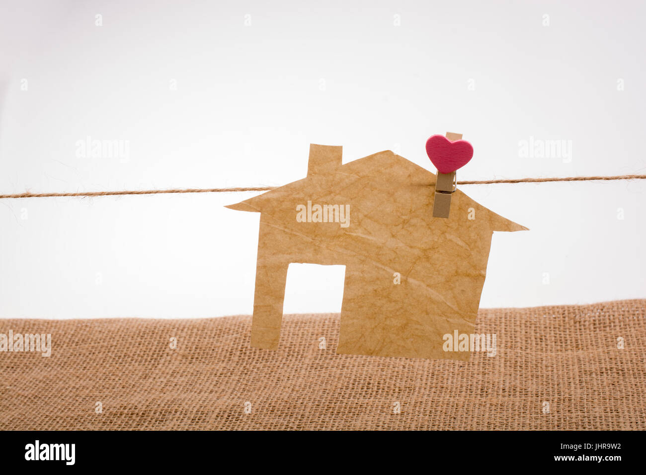 Little paper house attached to a string with a heart clip Stock Photo ...
