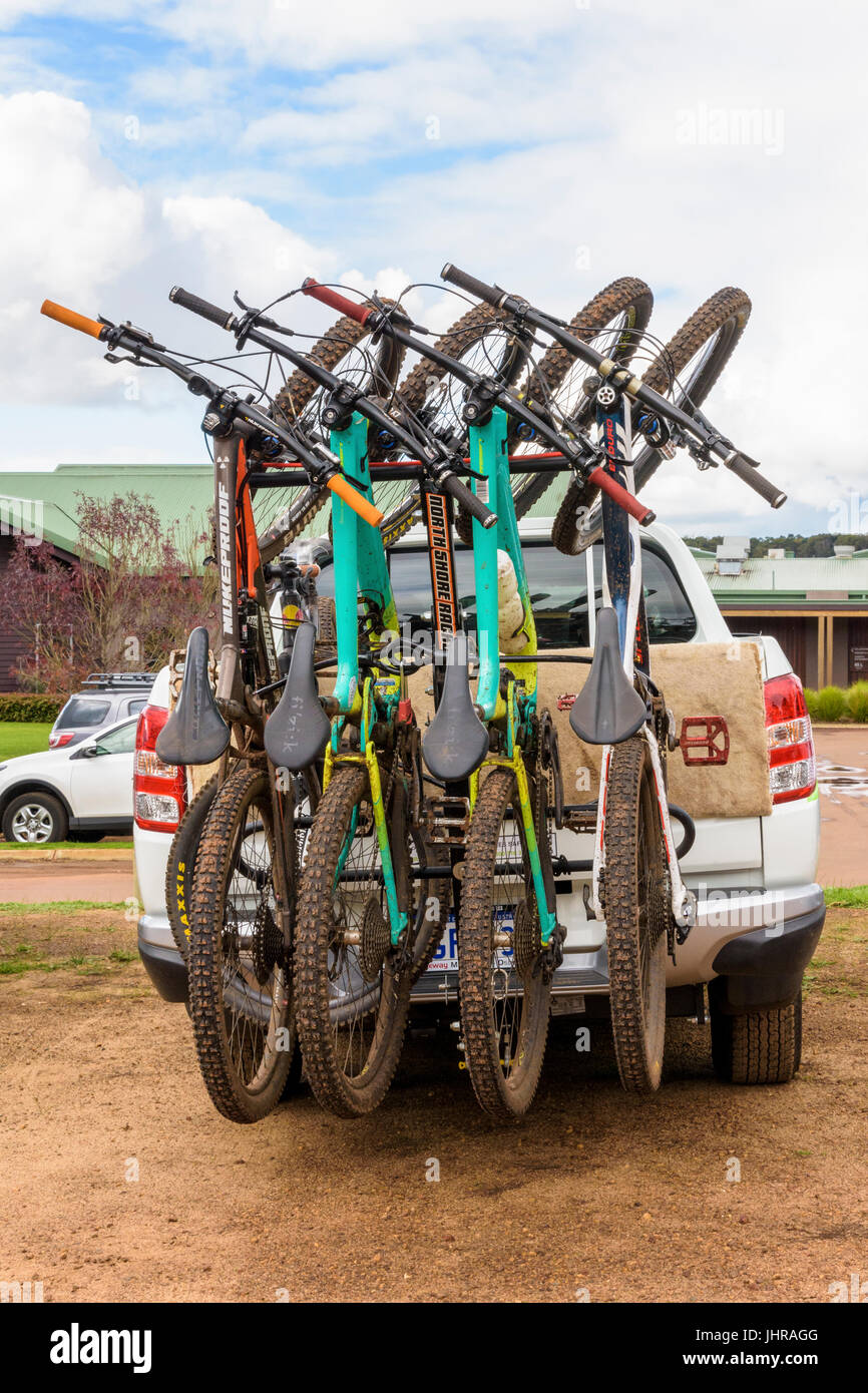 Muddy mountain bikes on a bike rack on the back ute in Western Australia Stock Photo