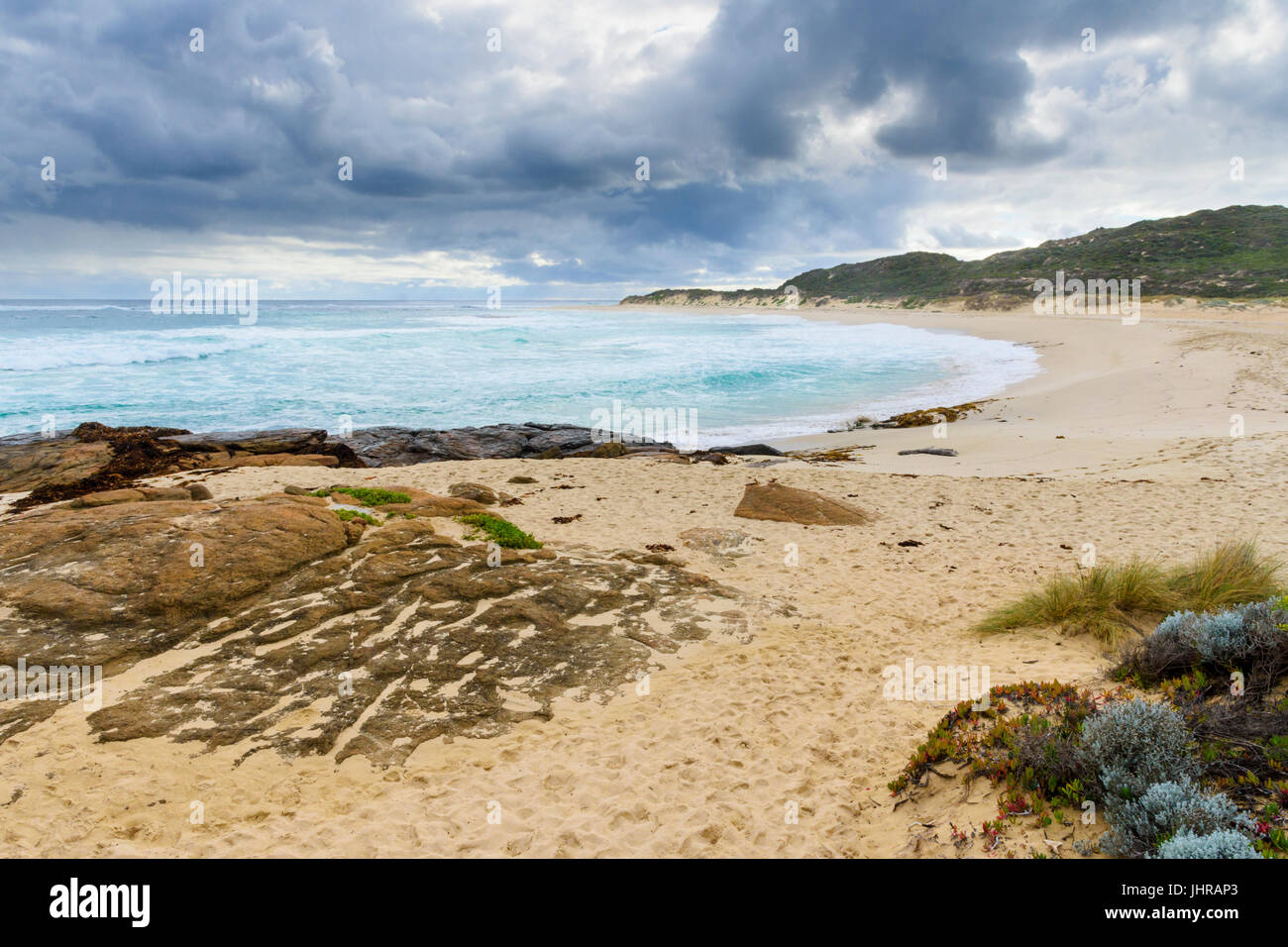 Winter storm clouds approach the sandy beach blocking the Margaret River river mouth in Prevelly, Western Australia Stock Photo