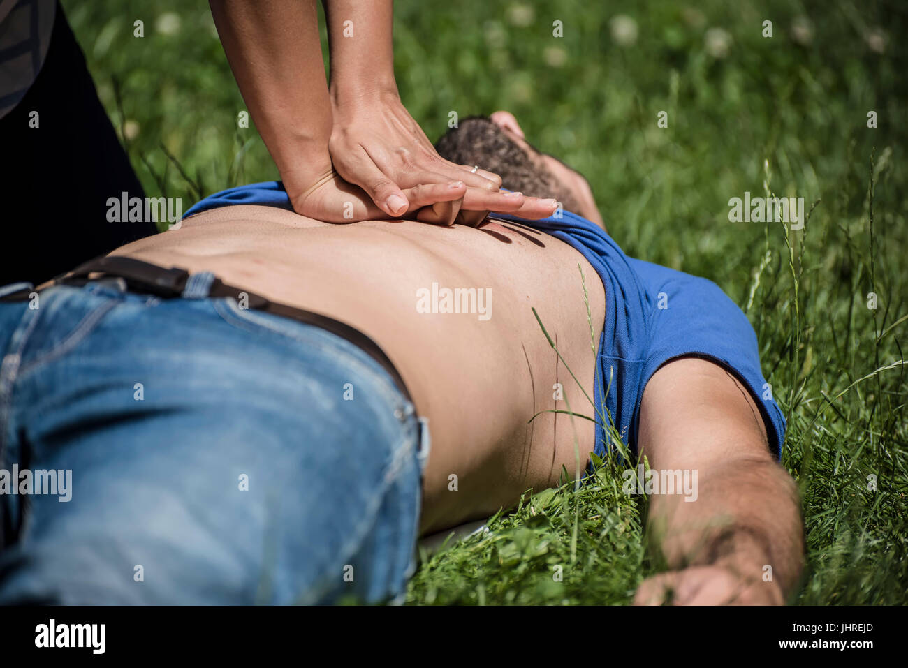 girl making cardiopulmonary resuscitation to an unconscious guy after heart attack Stock Photo