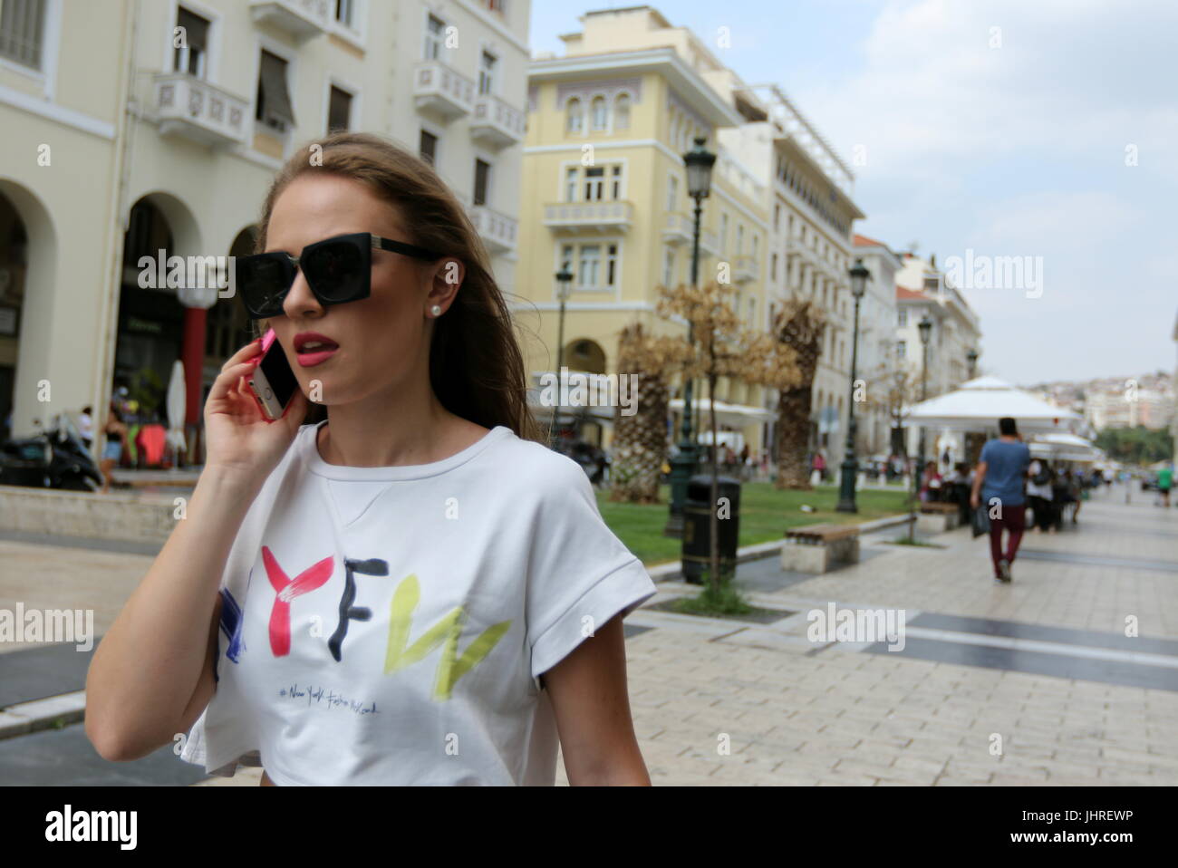 Woman walking in the street talking on the phone. Stock Photo
