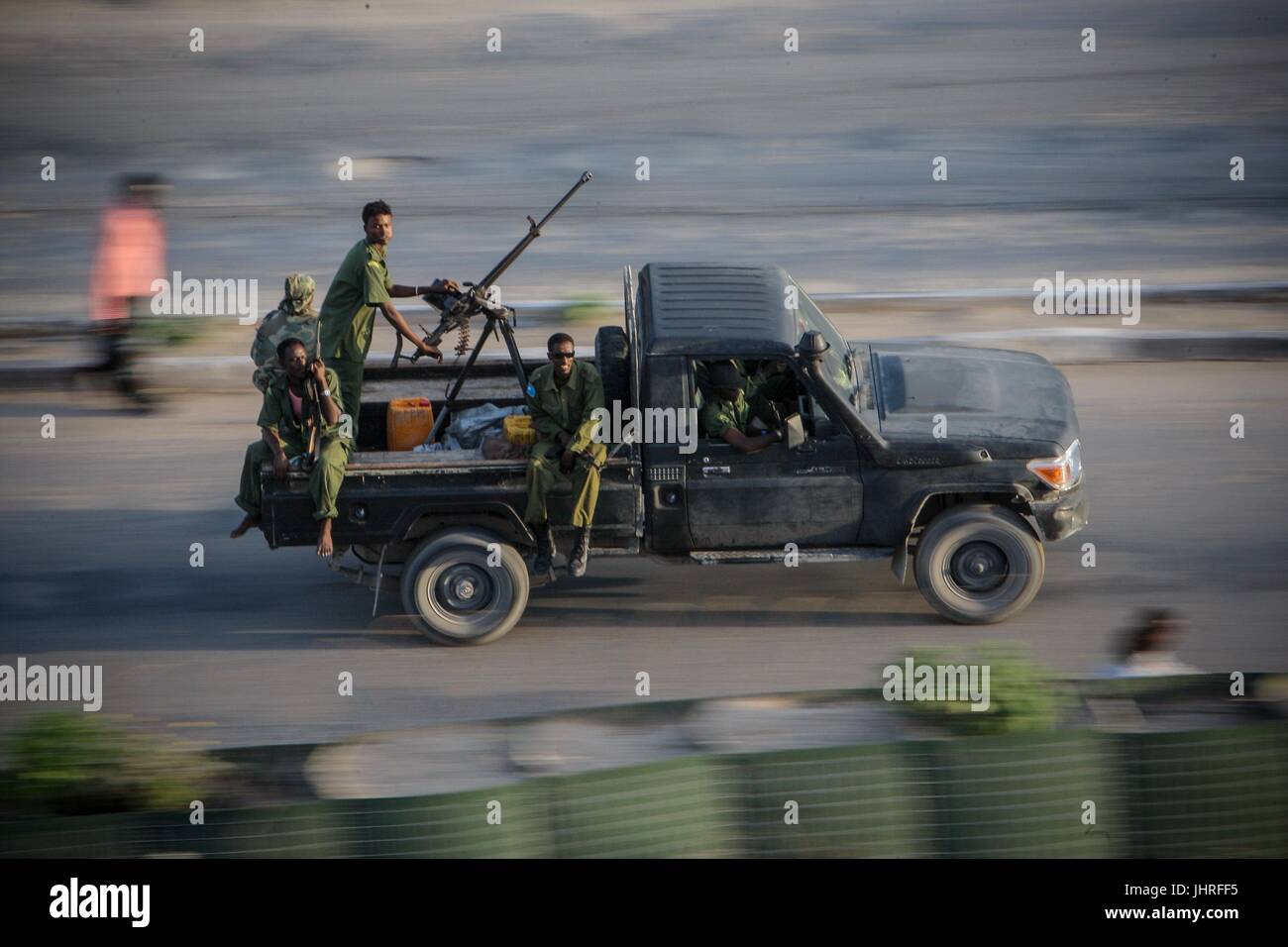 Somali National Army soldiers man a mounted machine gun as their vehicle races along a road near the parliament building August 6, 2012 in Mogadishu, Somalia.    (photo by Stuart Price  via Planetpix) Stock Photo