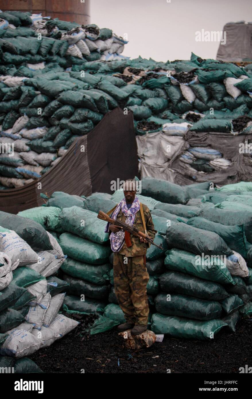 A Somalian soldier guards sacks of charcoal October 2, 2012 in Kismayo, Somalia.    (photo by Stuart Price  via Planetpix) Stock Photo