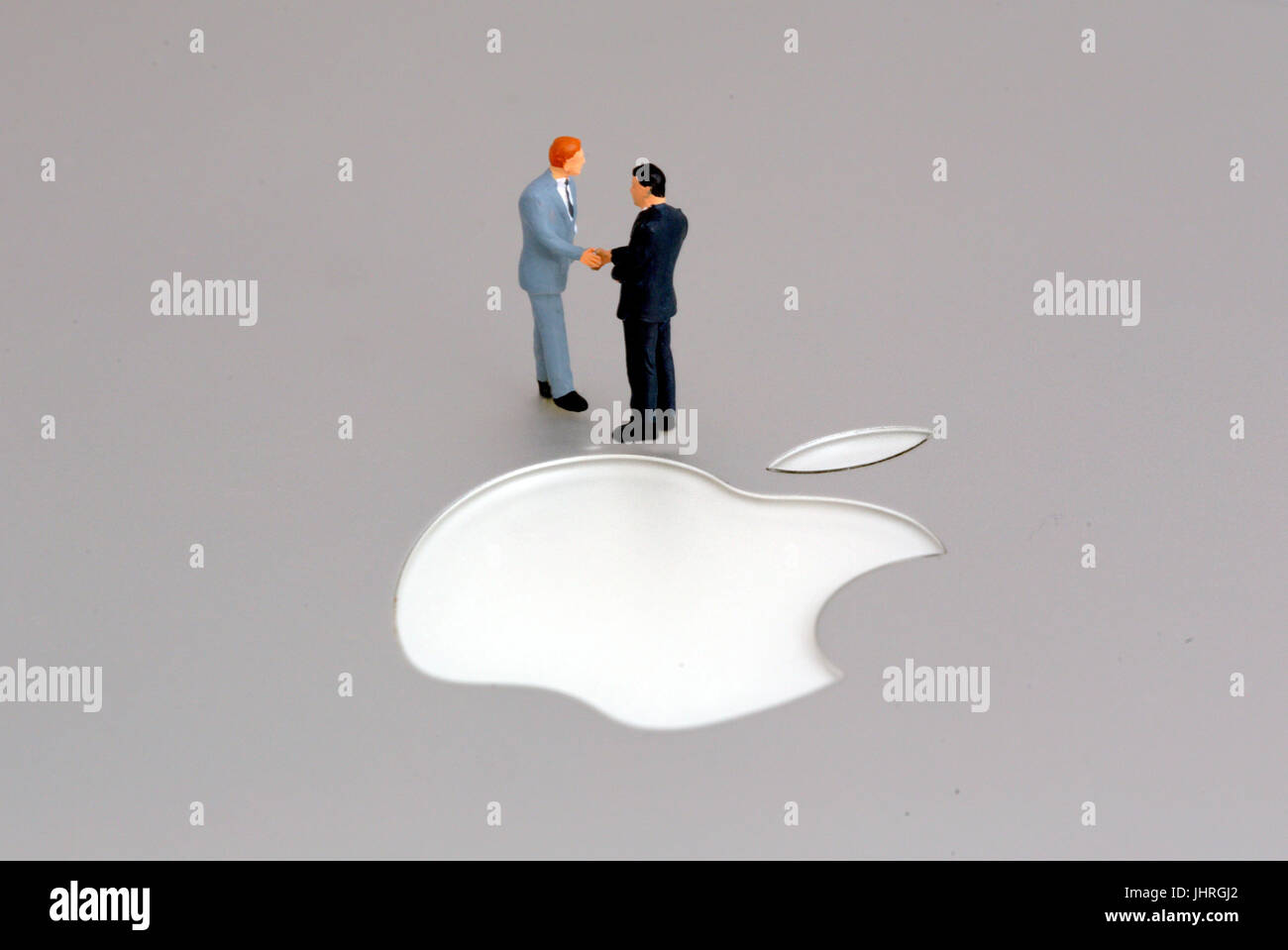 Apple corporation Apple Inc logo business agreement suits businessmen shaking hands Stock Photo
