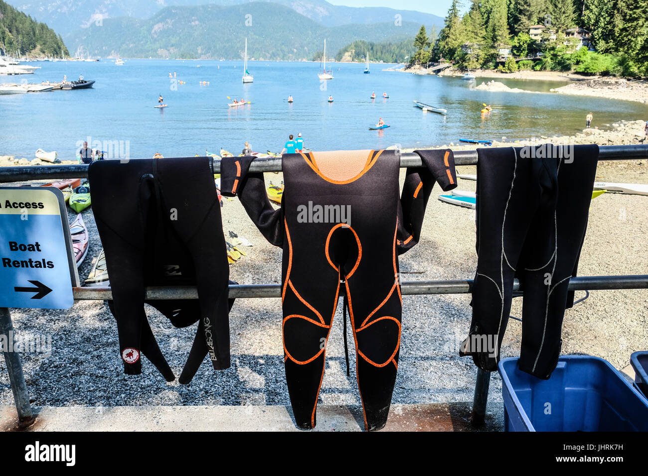 Three wet suits hanging on a railing at Panorama Park at Vancouver, British Columbia, Canada