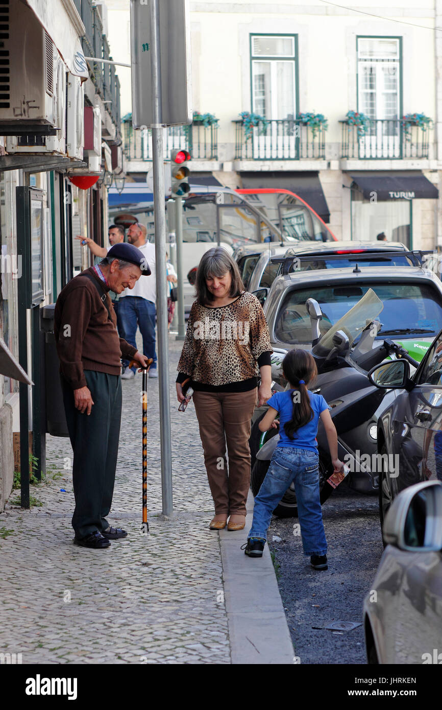 Three generations on street in lower Alfama neighborhood Lisbon Portugal Stock Photo