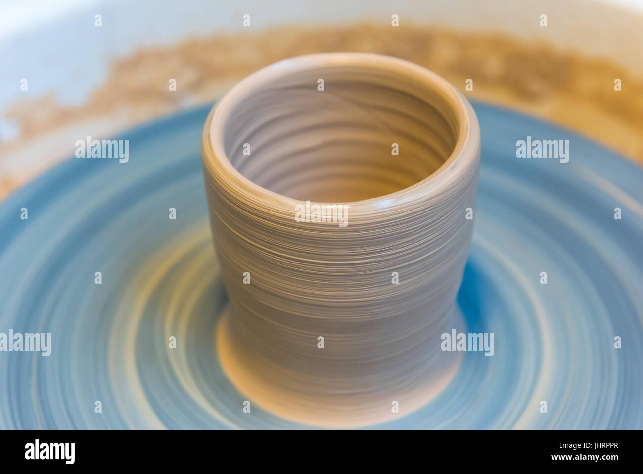 Pottering creating a clay cup in process. Horizontal shot with a
