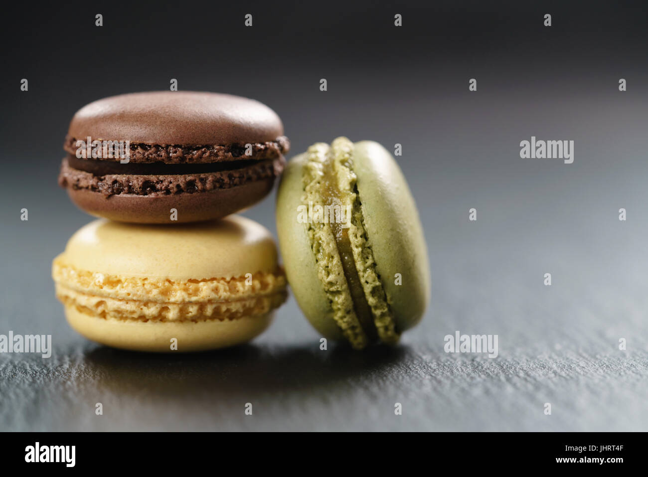 three assorted macarons on slate board Stock Photo