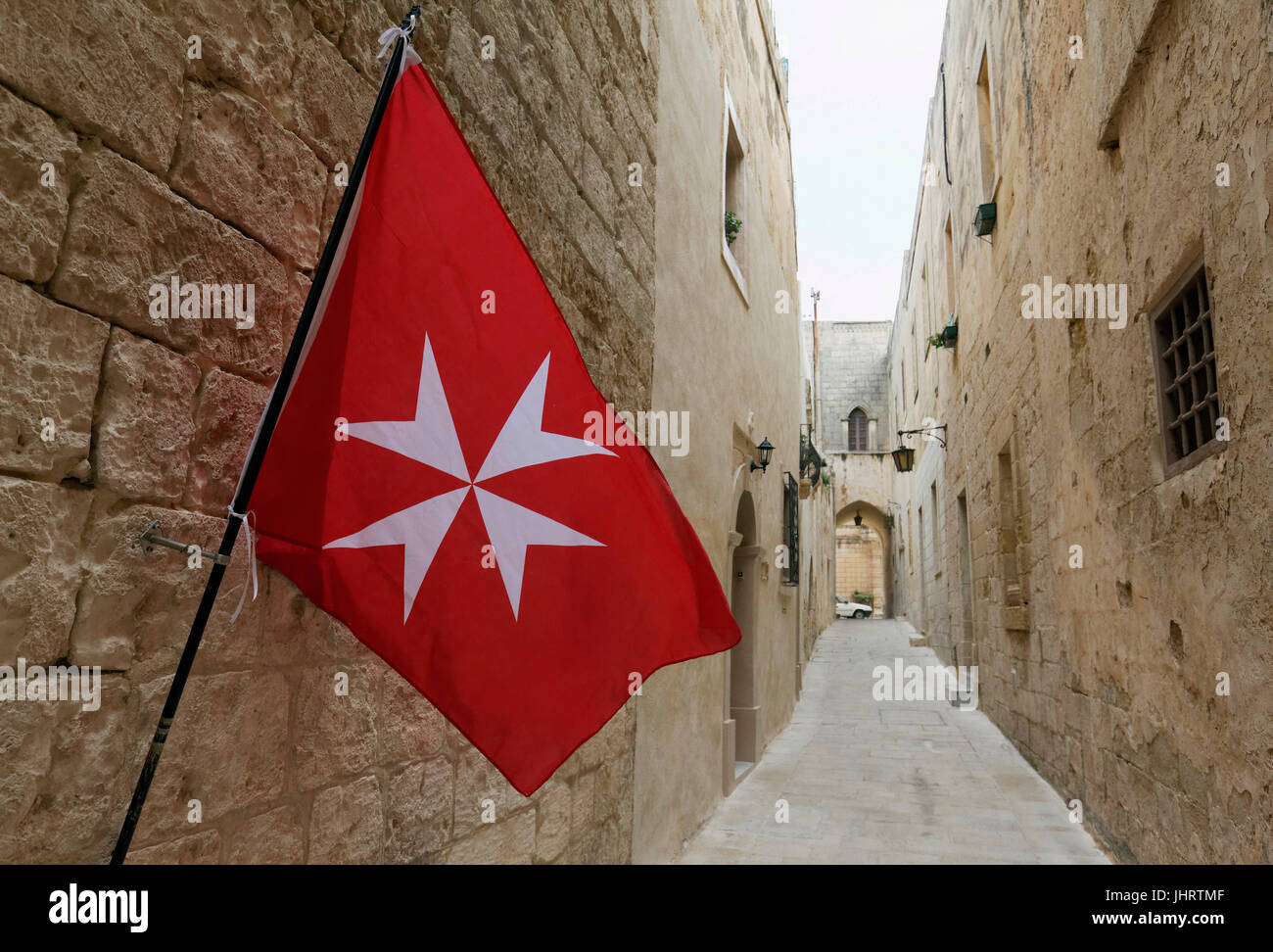 Maltese flag in narrow alleyway in historic centre, Mdina, Malta Stock Photo