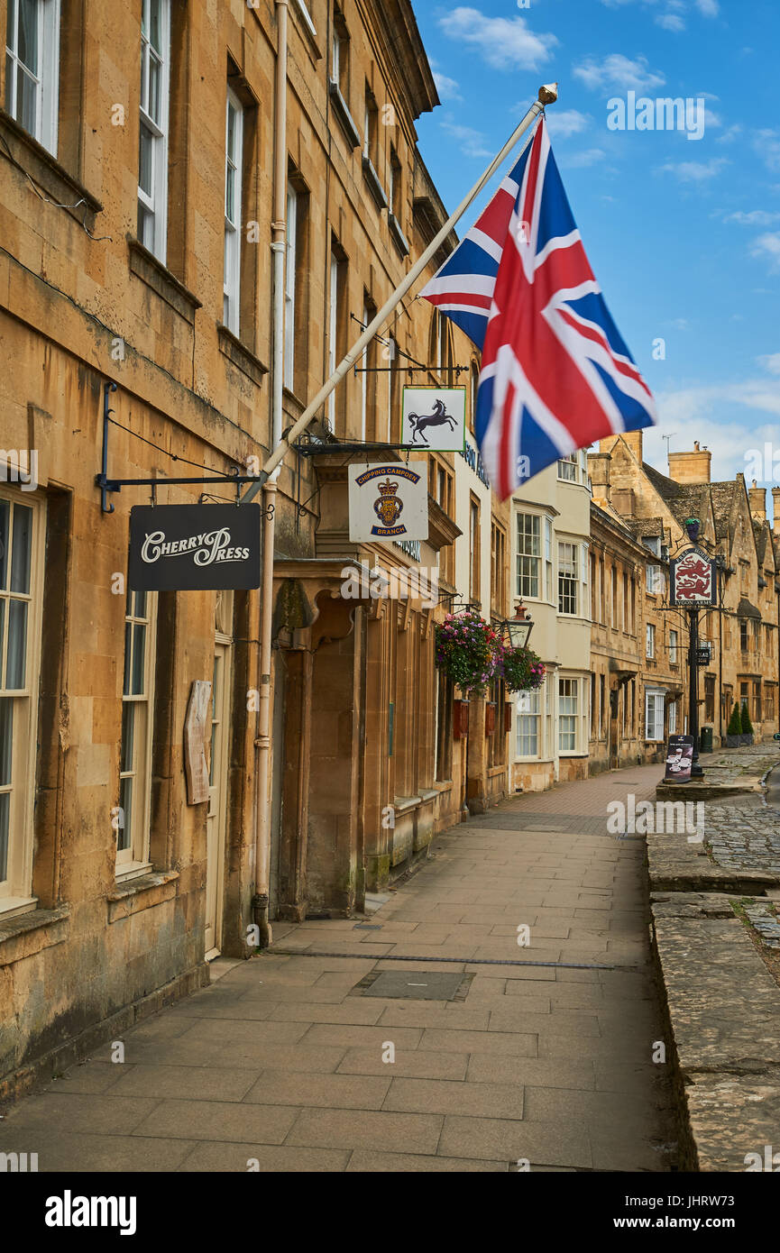 Chipping Campden High Street and a Union Jack flag flying from the from of a stone building in the Cotswold market town. Stock Photo