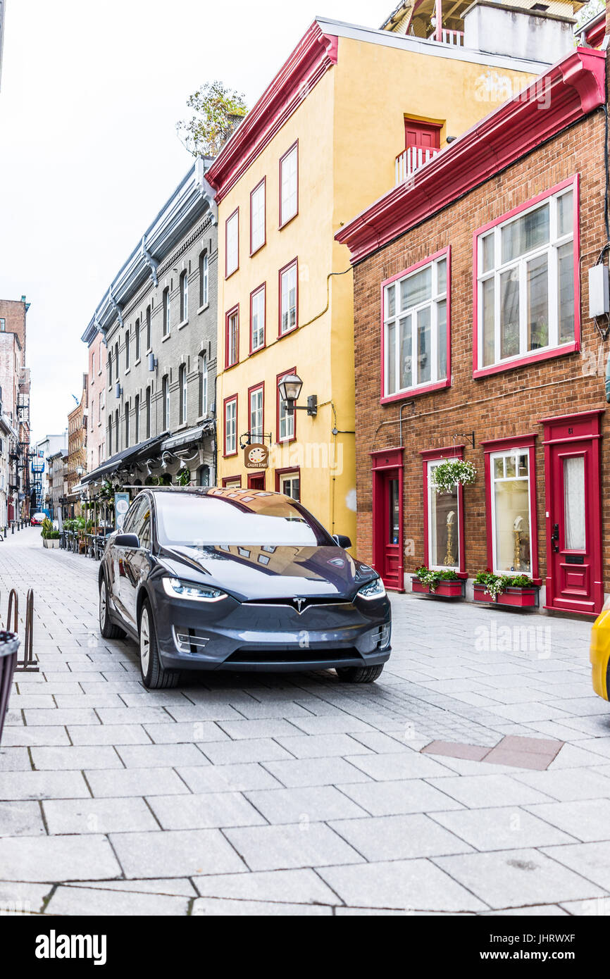 Quebec City, Canada - May 30, 2017: Blue Tesla Model X driving on cobblestone road in lower old town street called rue Sault-au-Matelot by restaurants Stock Photo
