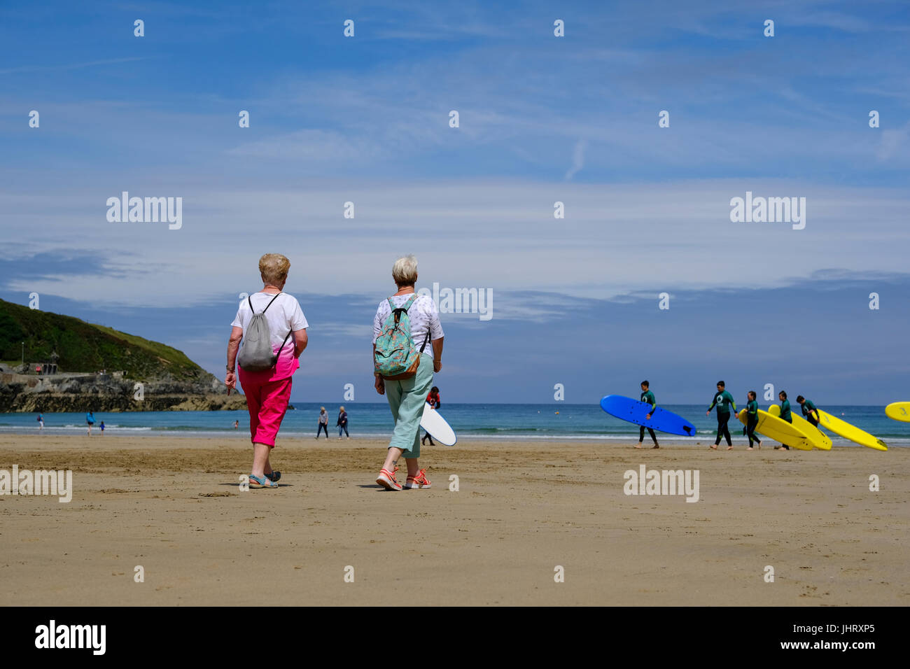 Two elderly women striding out across the beach in Newquay, Cornwall Stock Photo