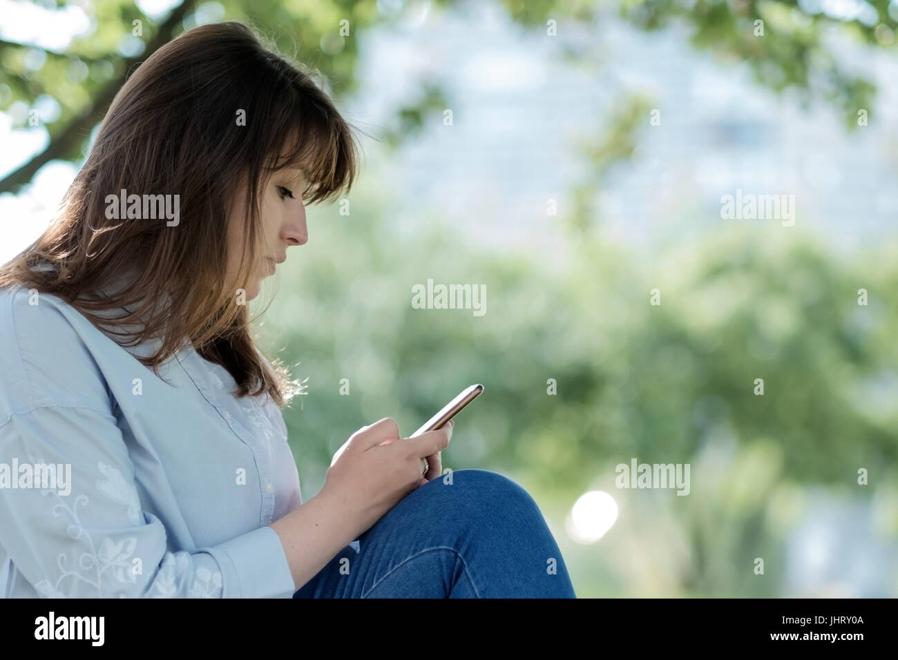 Young woman with a mobile phone in nature Stock Photo