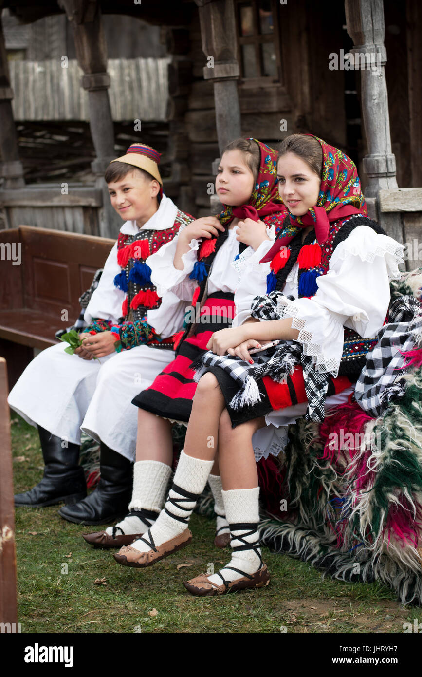 Young boy and girls with traditional costumes sitting on a bench during  Folk Festival in Sighetu Marmatiei, Maramures District, Romania Stock Photo  - Alamy