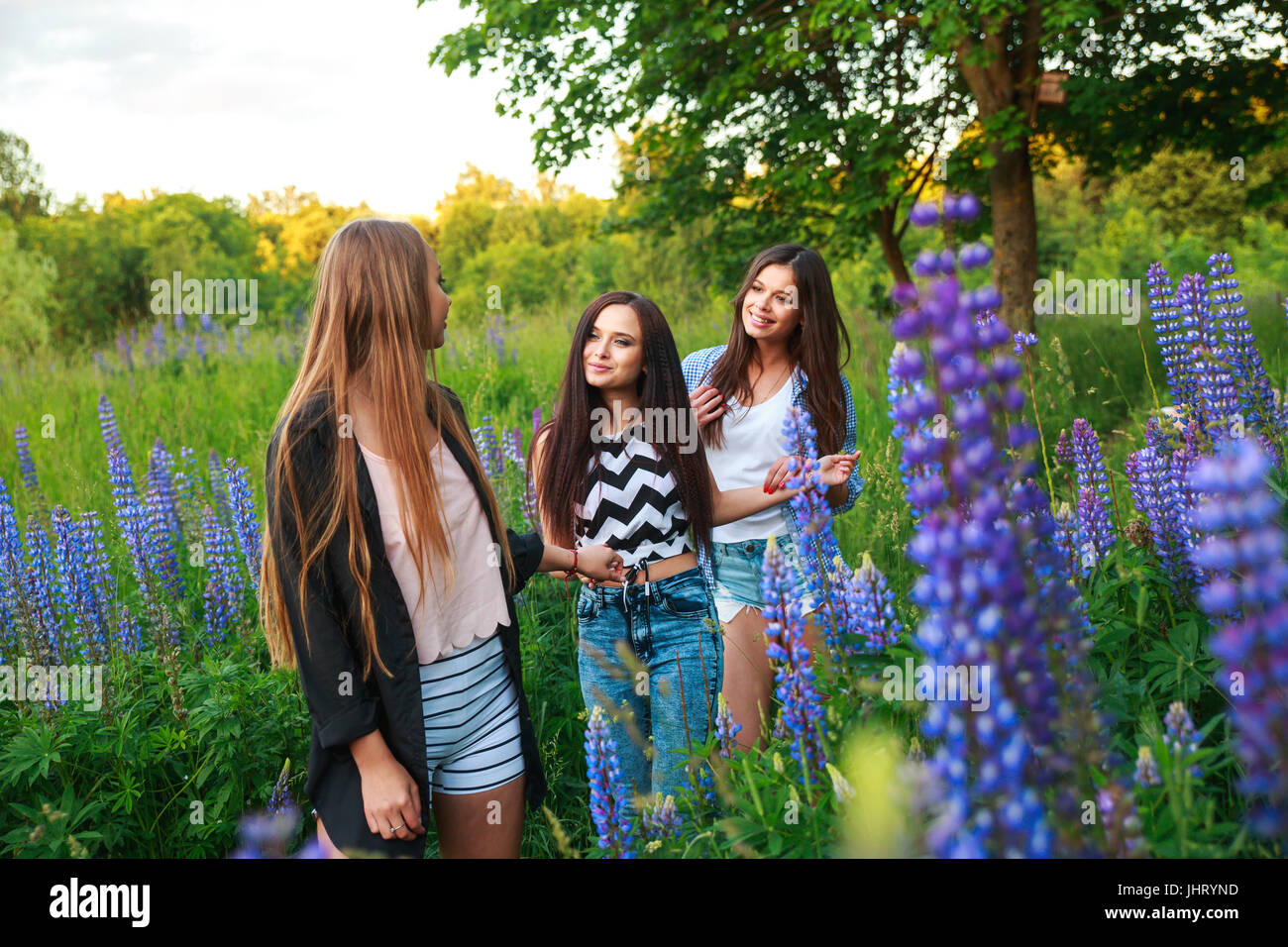Portrait of happy smiling friends on weekend outdoor. Three beautiful young happy girls best friends having fun, smiling and laughing. Stock Photo