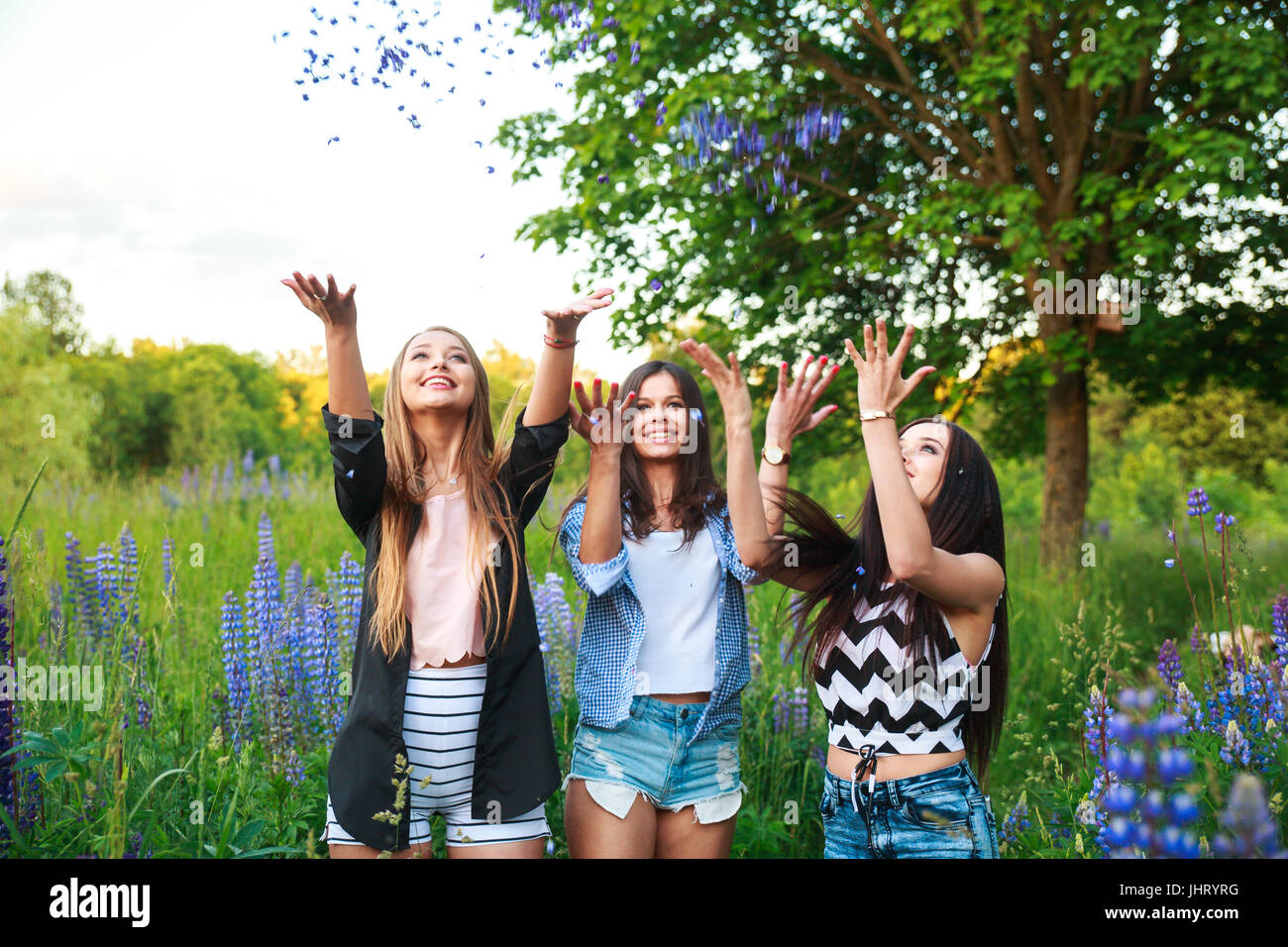 Portrait of happy smiling friends on weekend outdoor. Three beautiful young happy girls best friends having fun, smiling and laughing. Stock Photo