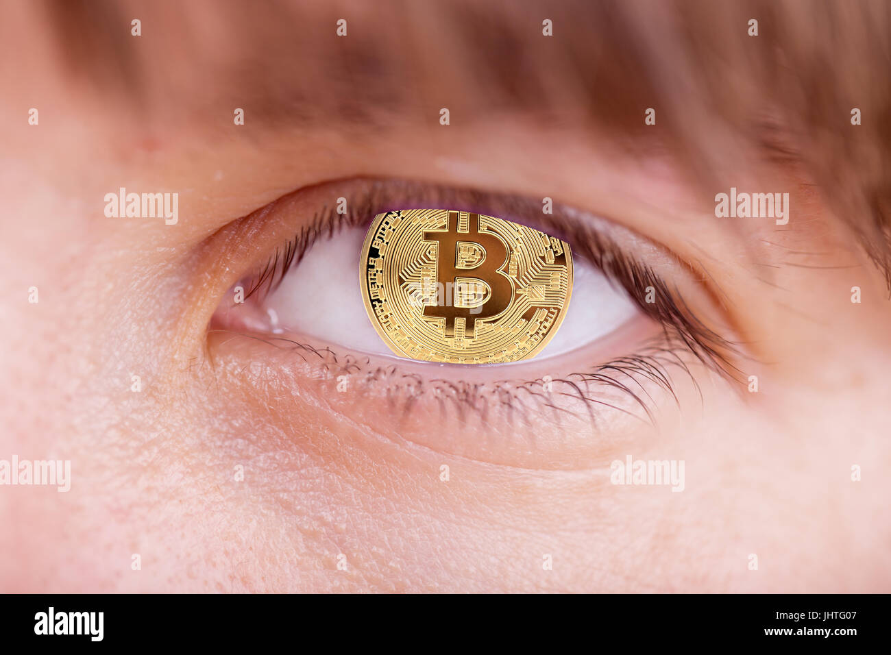 woman with gold bitcoim signs in she eye Stock Photo