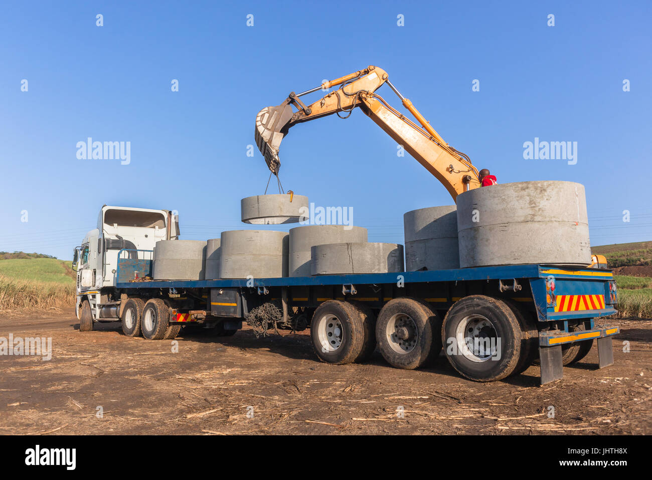 Truck loaded with new concrete drain water pipes waste casting sections