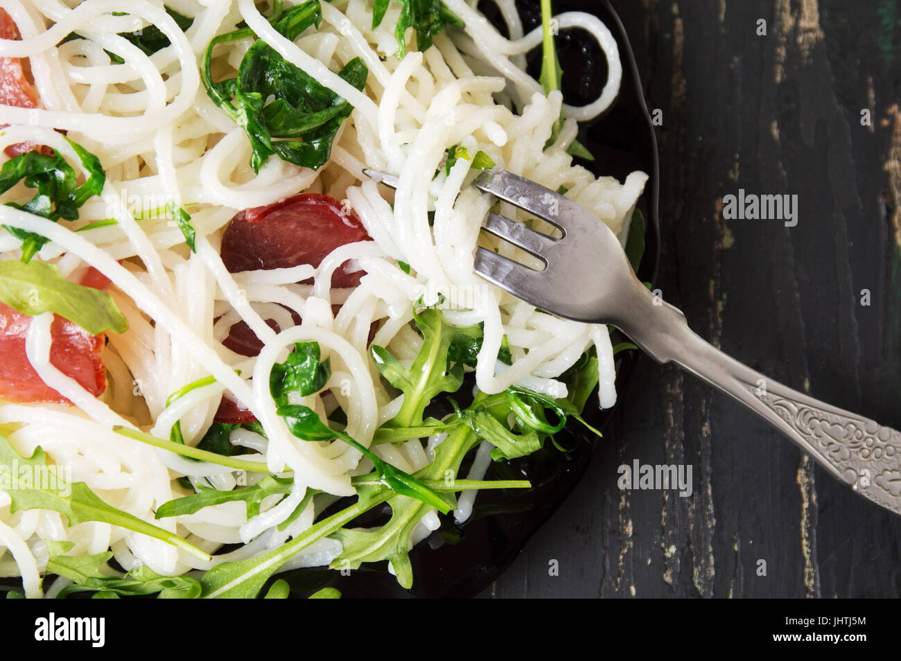 Pasta with prosciutto and arugula vegetable served on a plate Stock Photo