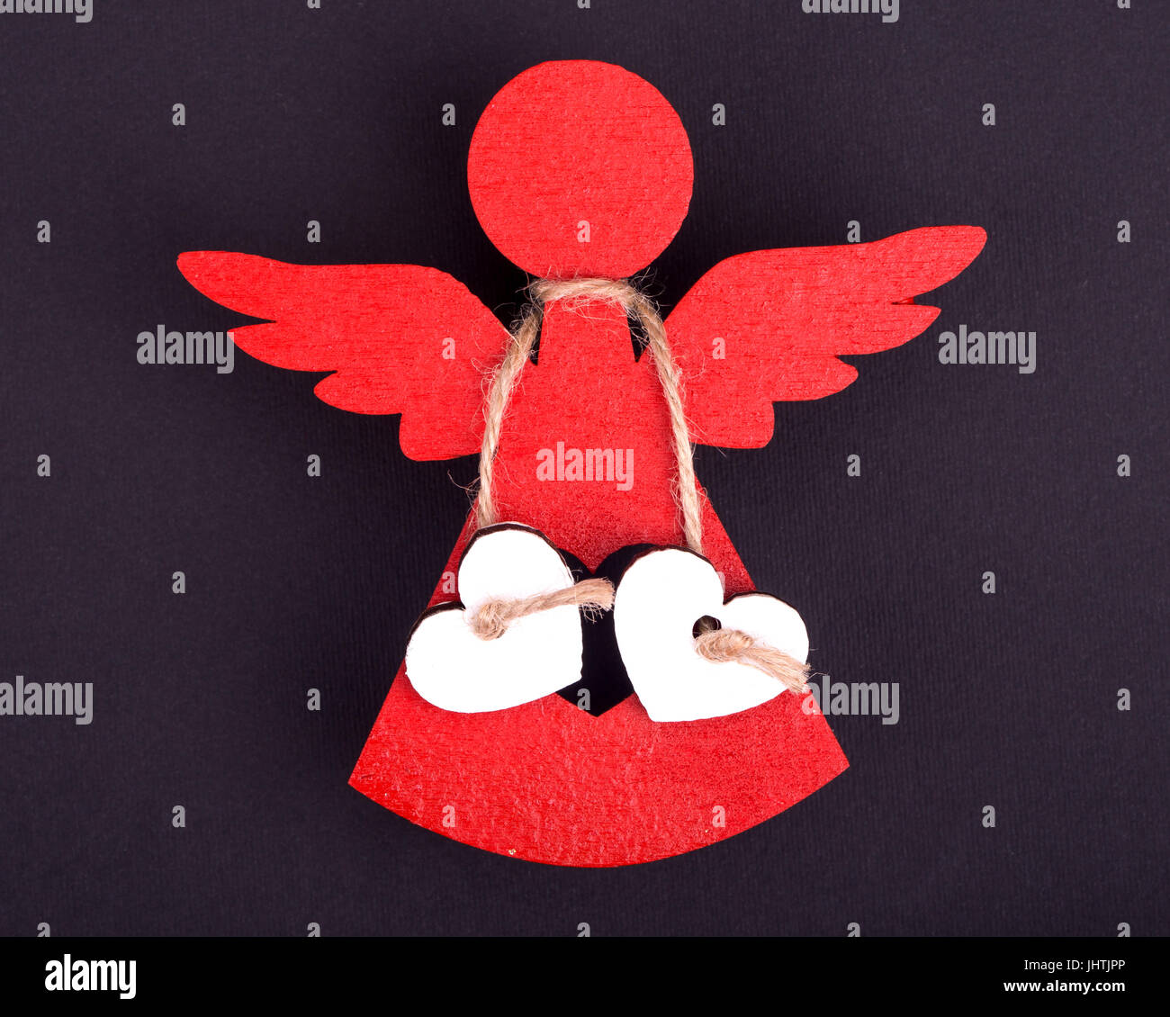 Christmas decorations of red angels two linked white hearts on a black background Stock Photo