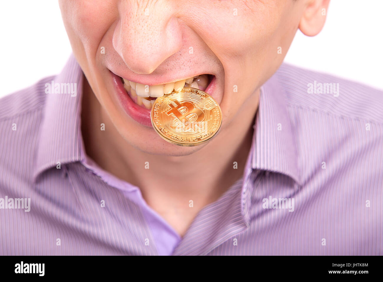 man with one gold bitcoin coin on a tooth isolated on white background Stock Photo