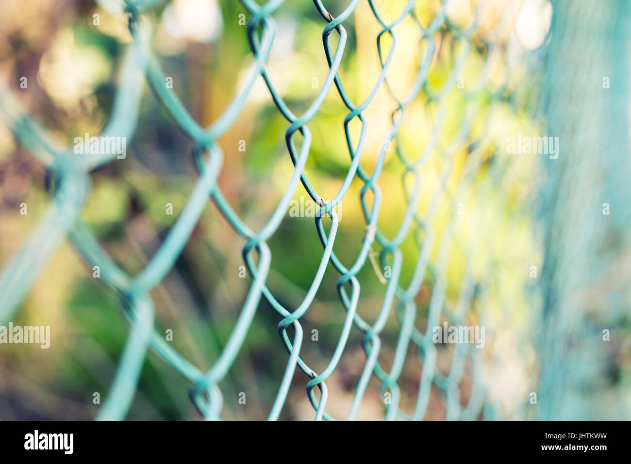 Wire fence with green grass on background Stock Photo - Alamy