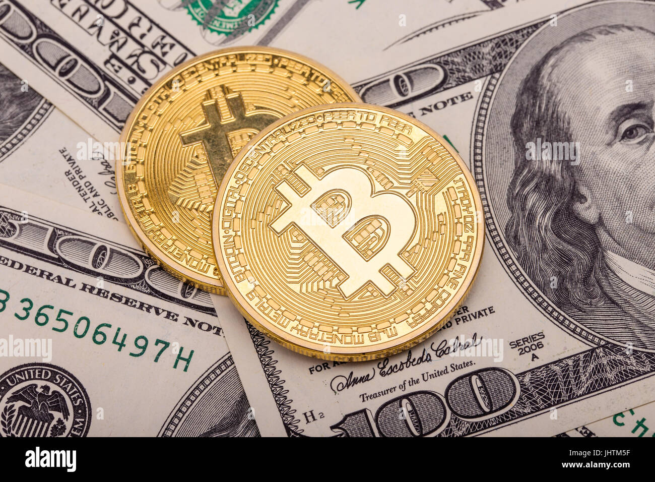 Two golden Bitcoins on US dollars. Electronic money exchange concept Stock Photo