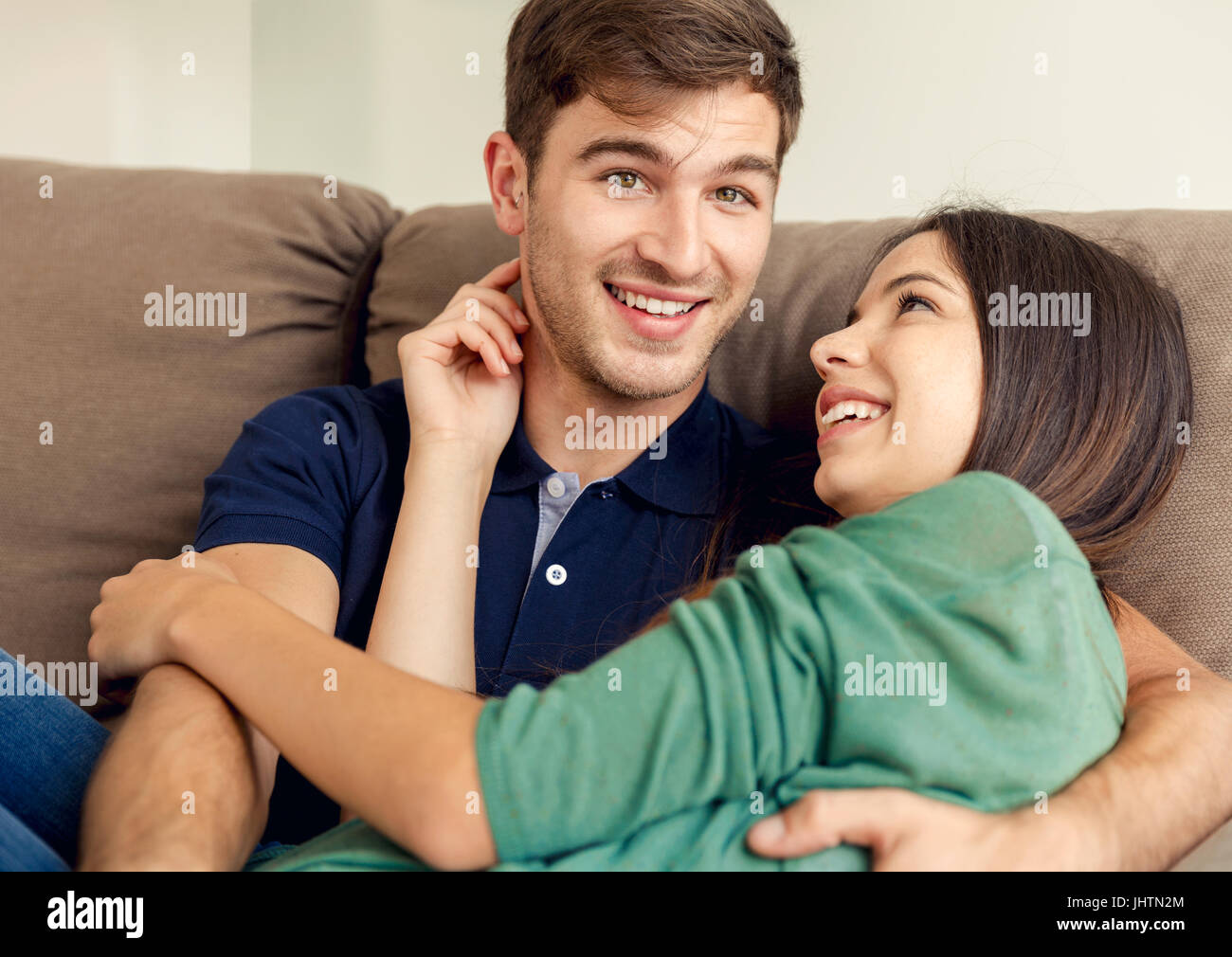 Young couple sitting on the sofa and dating Stock Photo