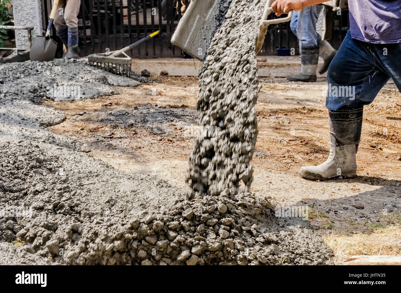 Men pouring concrete mix on road Stock Photo Alamy
