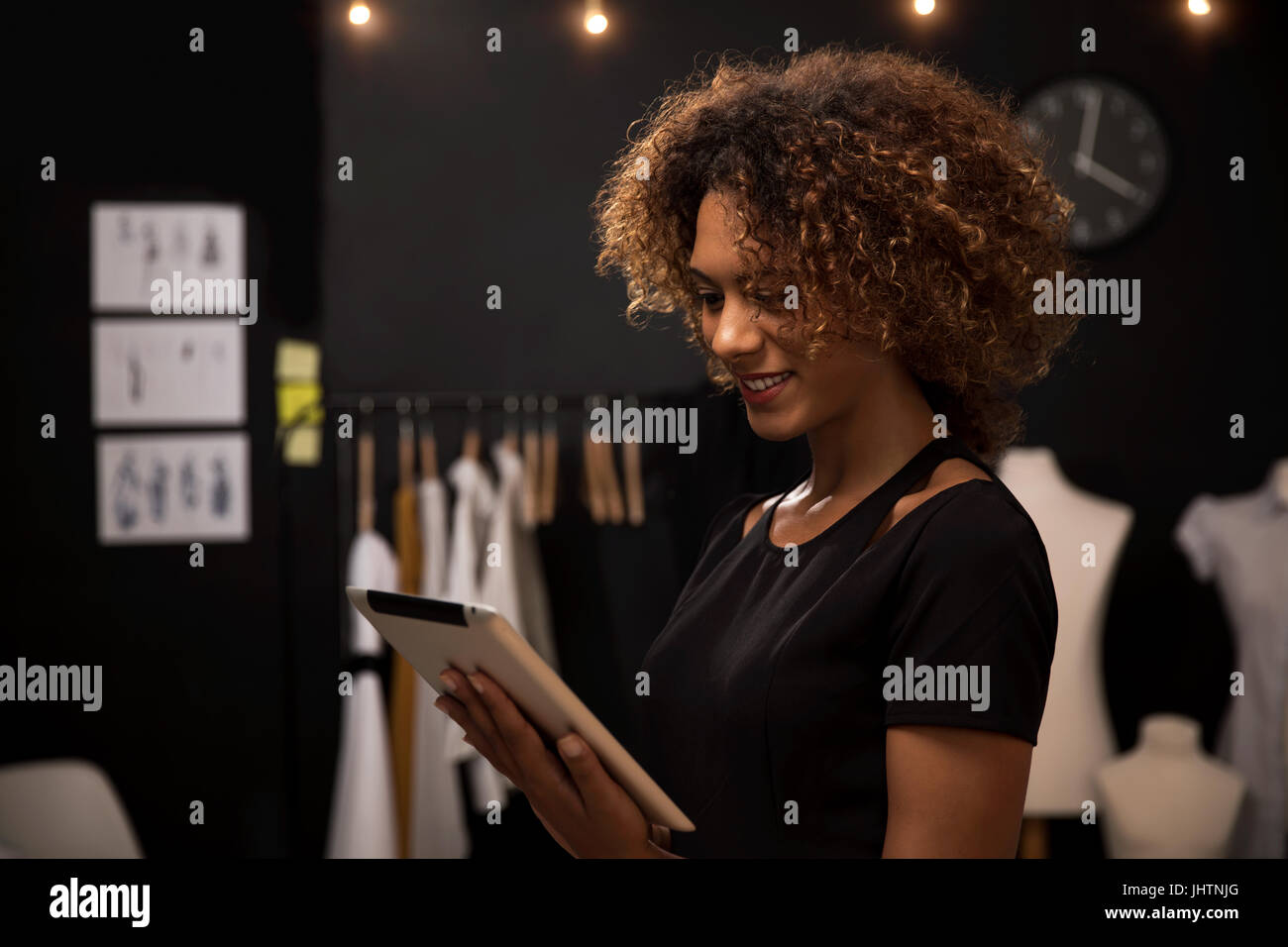 A young fashion designer on her atelier working with a tablet Stock ...