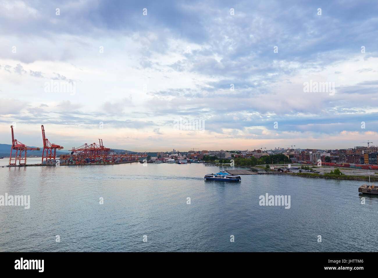 Vancouver skyline with container port terminal at sunset, British Columbia, Canada. The city harbor at sunset with clouds Stock Photo