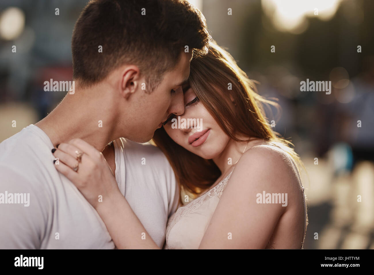 Portrait of young couple in love, enjoying the sunset in city Stock Photo