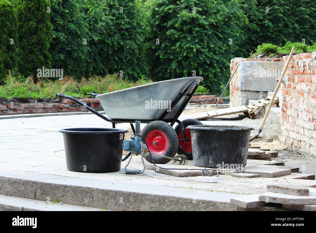A wheelbarrow, a professional hand mixer, cement mortars and shovels