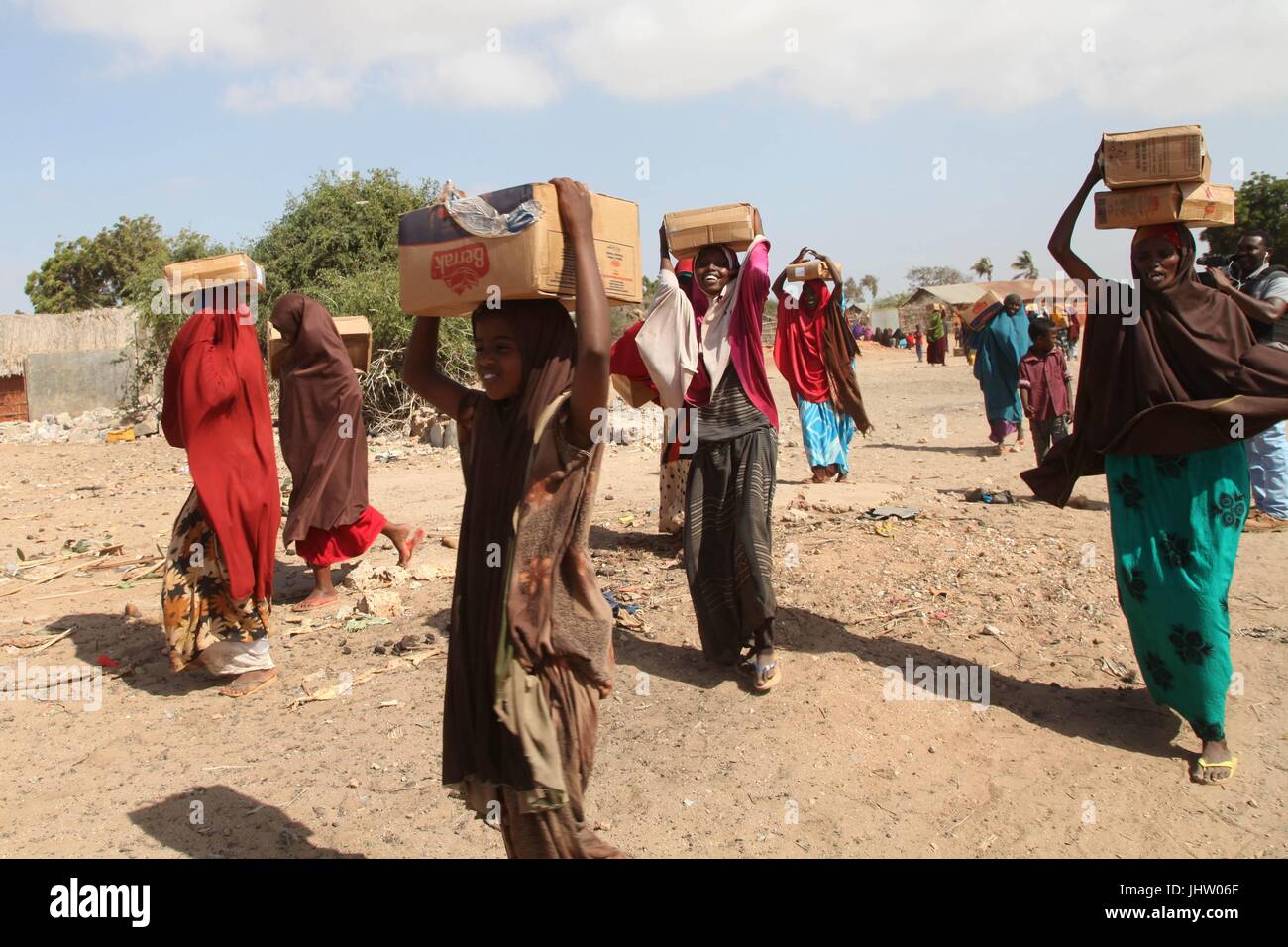 Somalian locals carry food donated by the Ethiopian National Defense Forces January 15, 2017 in Goob Weyn, Lower Juba region, Somalia.    (photo by Awil Abukar  via Planetpix) Stock Photo