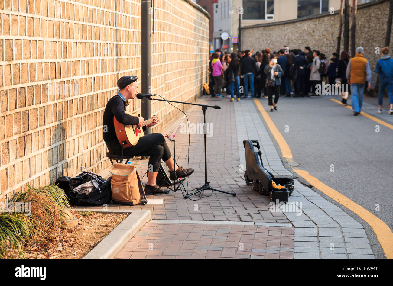 Seoul, south Korea - Mar 19, 2017: A young man busking with guitar and microphone in Insadong street. Stock Photo