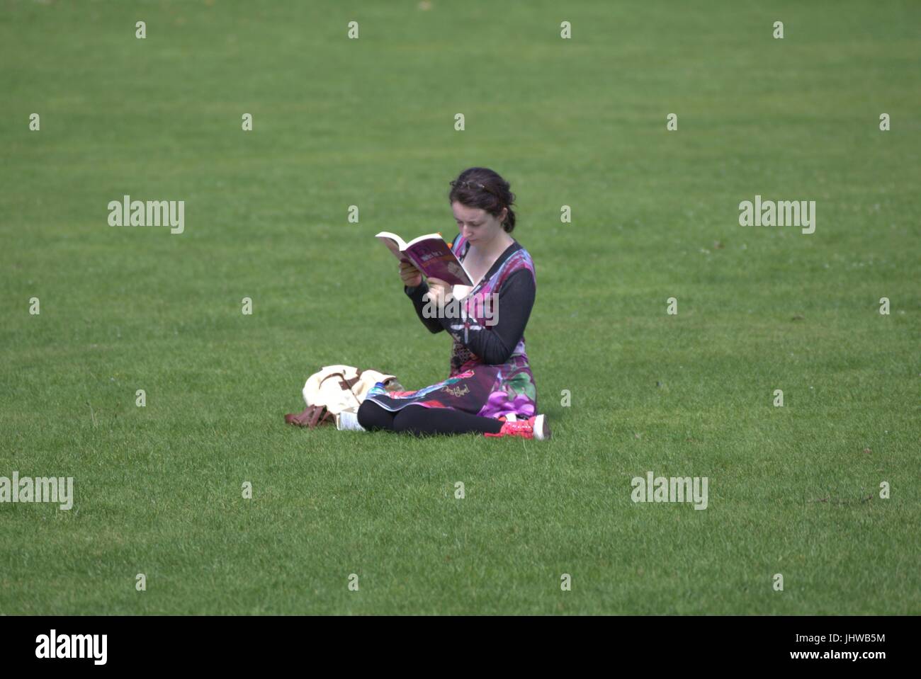 Botanic Gardens Glasgow sunny day young teenage girl reading book alone Stock Photo