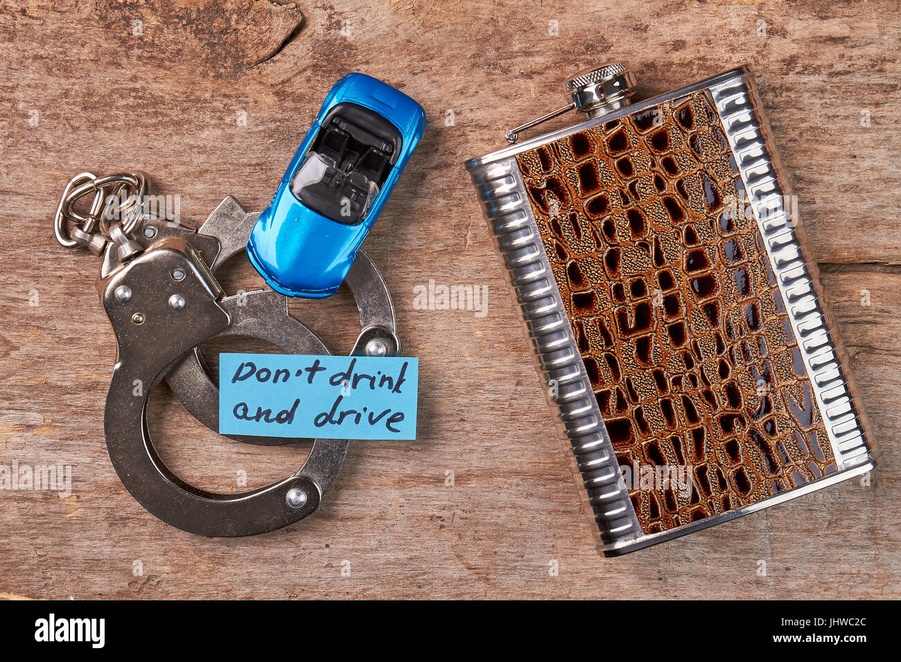 Handcuffs, toy car, message, hip flask. Stock Photo