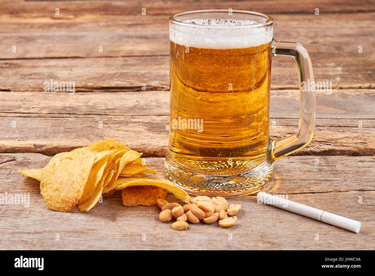 Glass of beer, chips, nuts, cigarette Stock Photo - Alamy