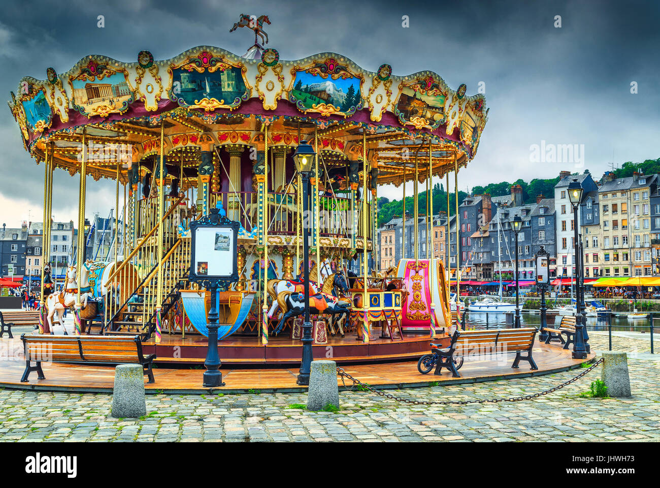 Spectacular retro carousel in the city. Merry-go-round with horses and landau in the famous French harbour, Honfleur, Normandy, France, Europe Stock Photo