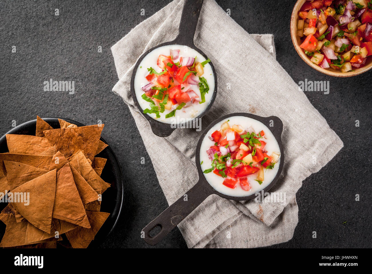 Mexican, LatinAmerican cuisine. Queso blanco recipe - cream cheese, cream, fresh stewed vegetables tomatoes, onions, peppers,  herbs. With Baked Torti Stock Photo