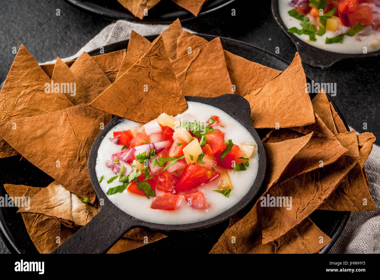 Mexican, LatinAmerican cuisine. Queso blanco recipe - cream cheese, cream, fresh stewed vegetables tomatoes, onions, peppers,  herbs. With Baked Torti Stock Photo