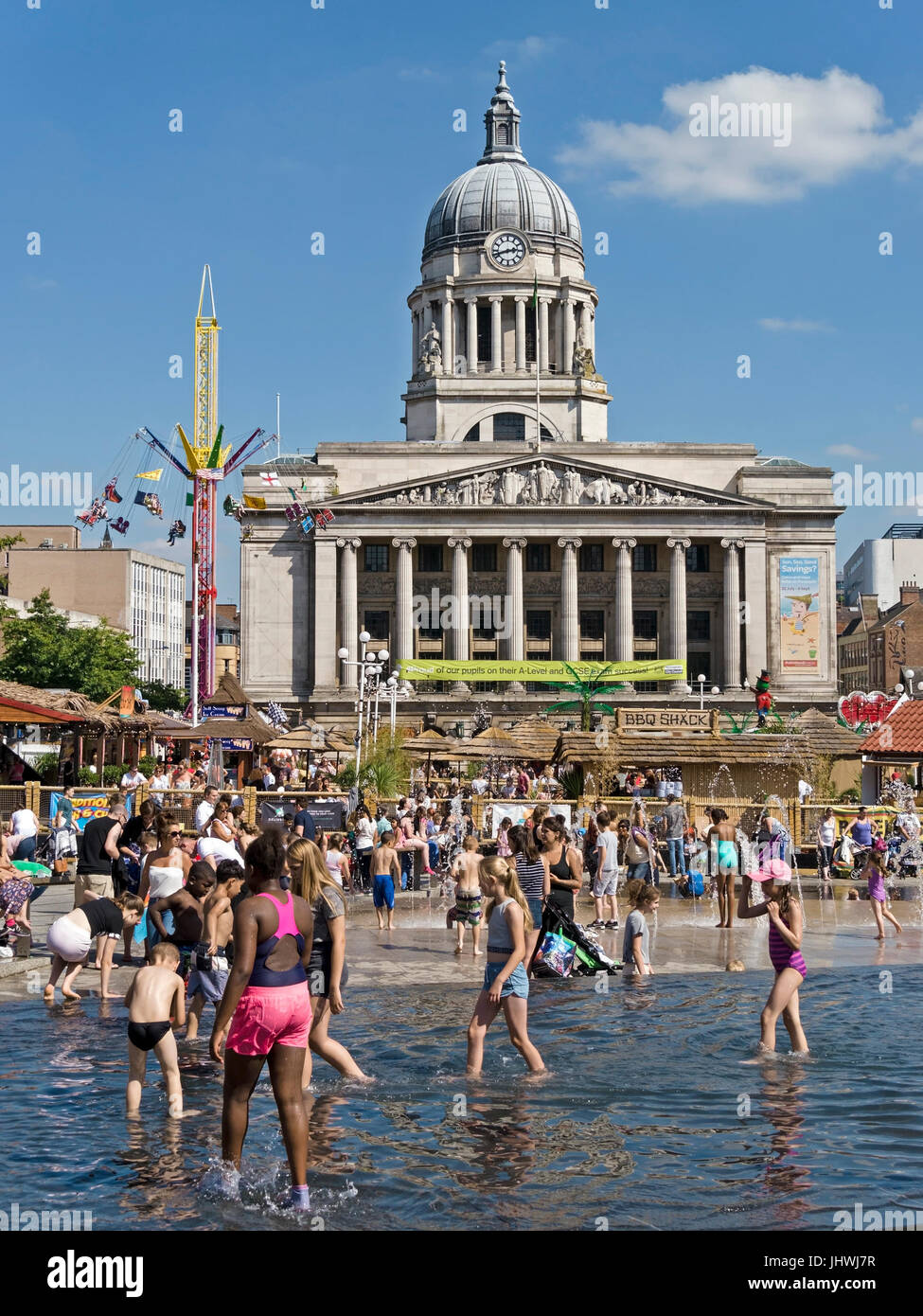Children playing in water fountains in Old Market Square during Nottingham Beach 2016 Summer fare with Nottingham City Hall beyond, Nottingham, UK. Stock Photo
