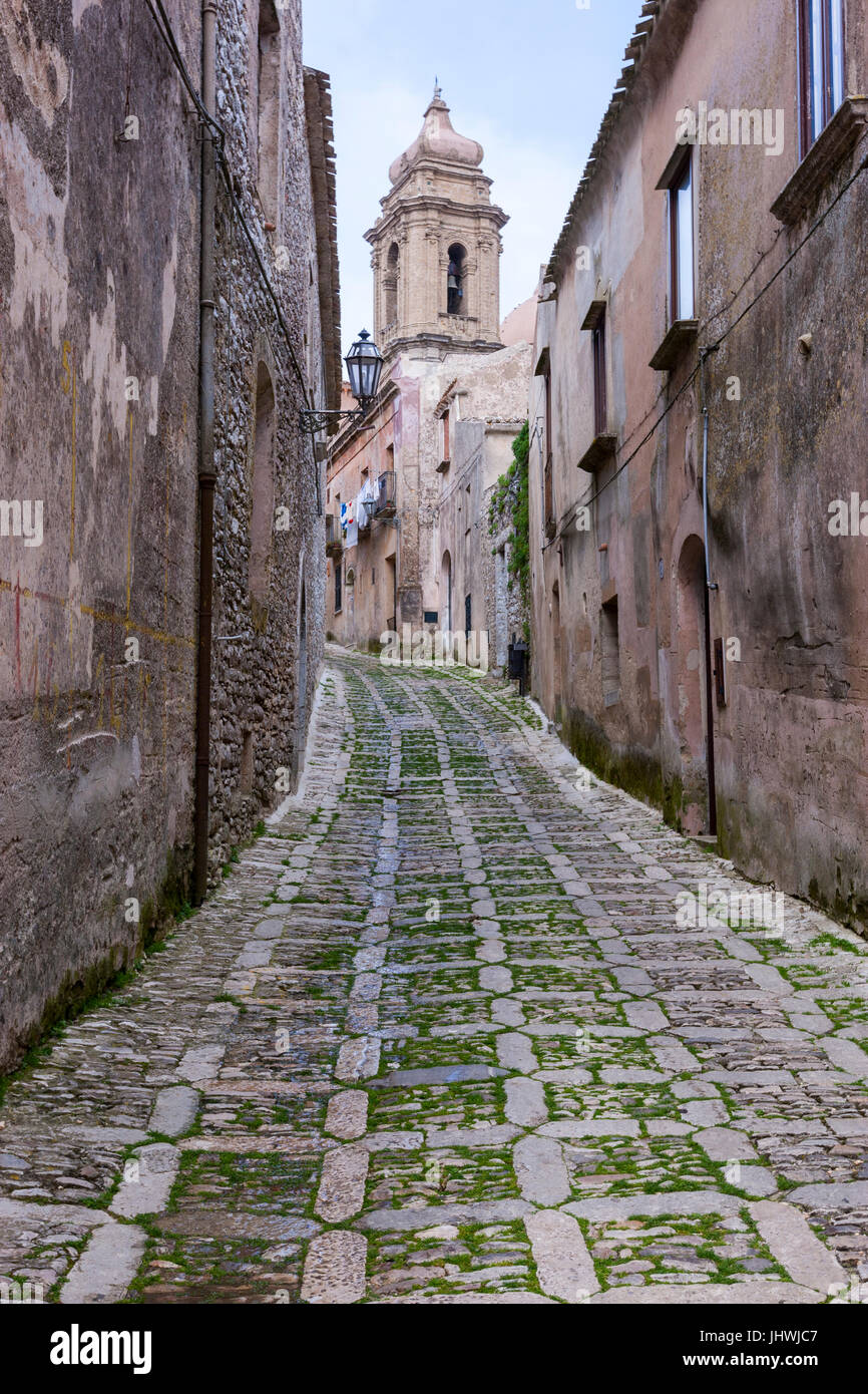Narrow street with stone houses and church in Erice, Sicily, Italy
