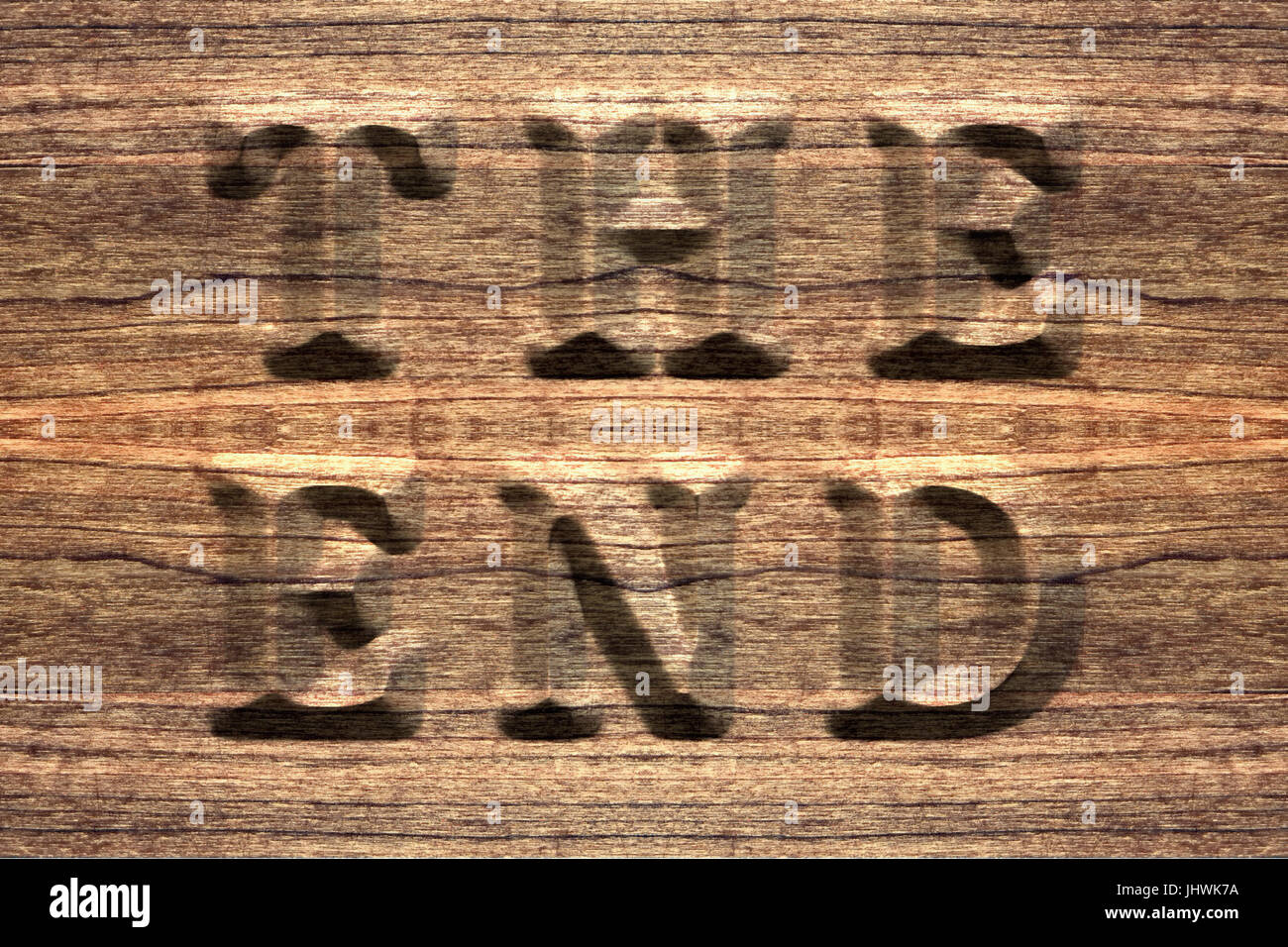 The end, sign on a seamless rustic wooden board, embossed letters. Stock Photo