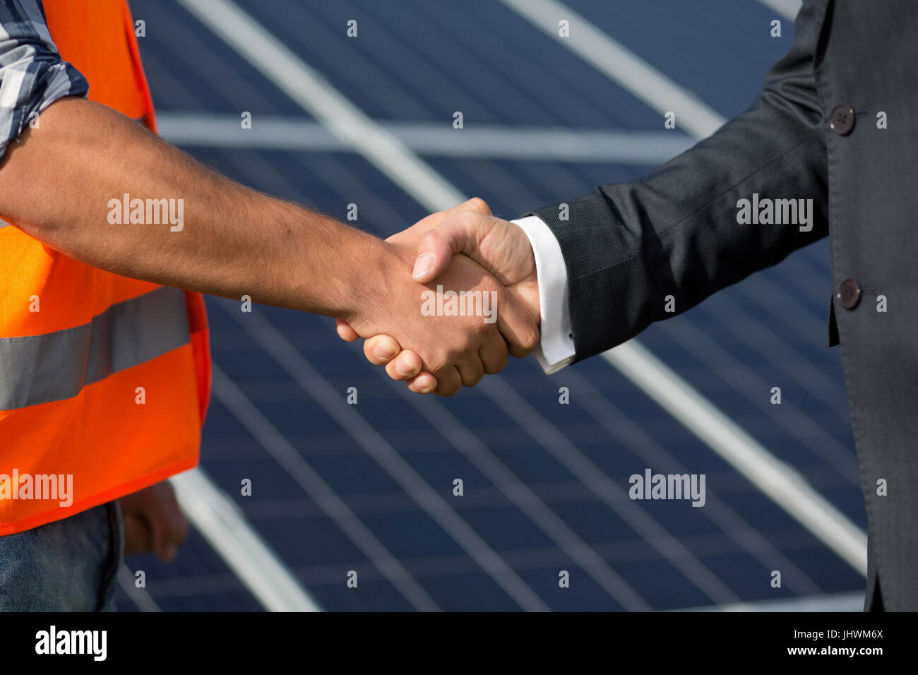 Foreman and businessman shaking hands at solar energy station. Stock Photo