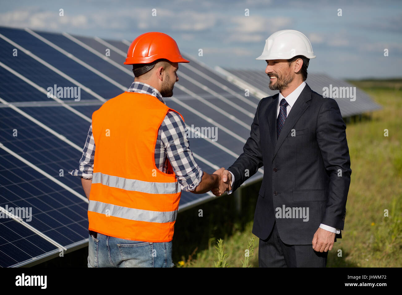 Businessman and foreman shaking hands at solar energy station. Stock Photo