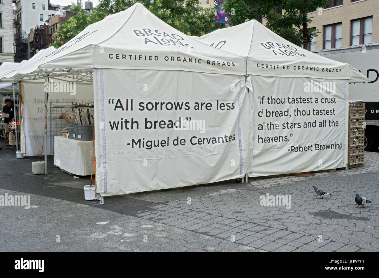 The BREAD ALONE stand at the Union Square Green Market with quotes by Robert Browning and Miguel de Cervantes on their tents. Stock Photo