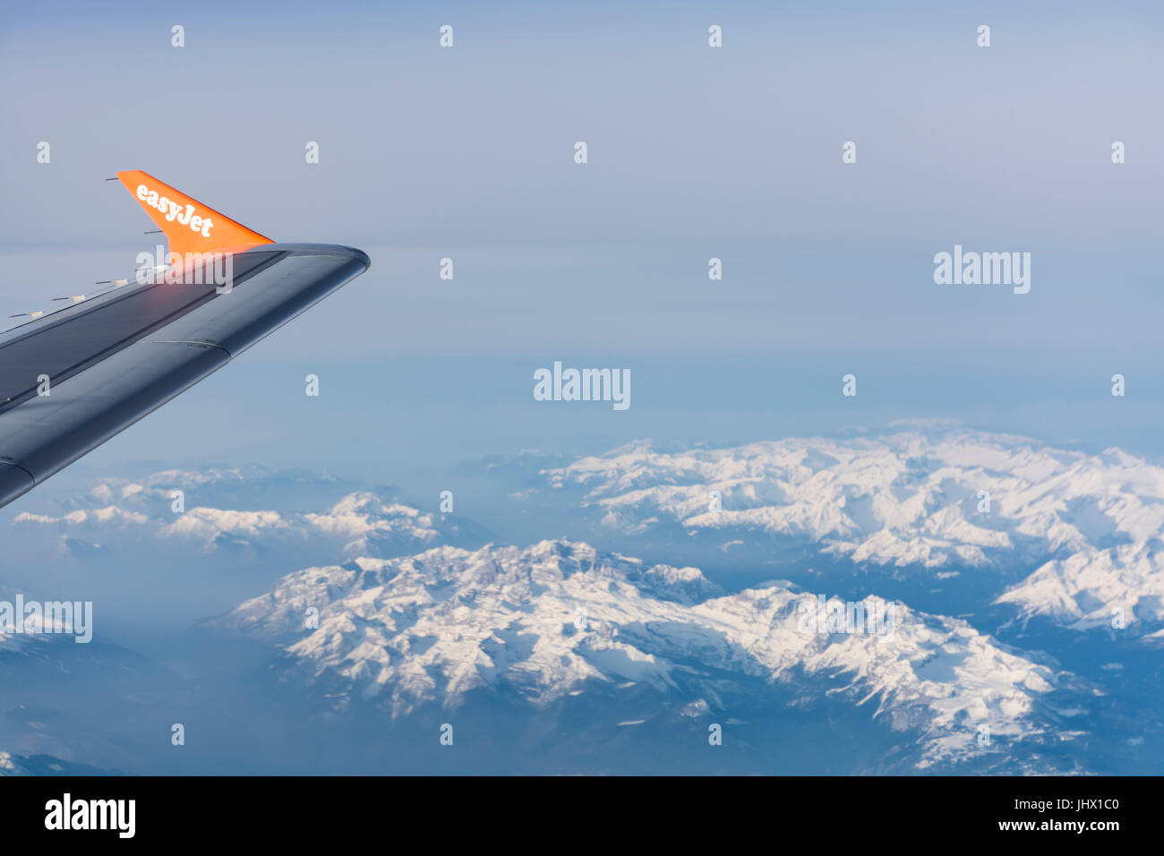 View of Easy Jet airplane wing from the window flying over the Alps Stock Photo