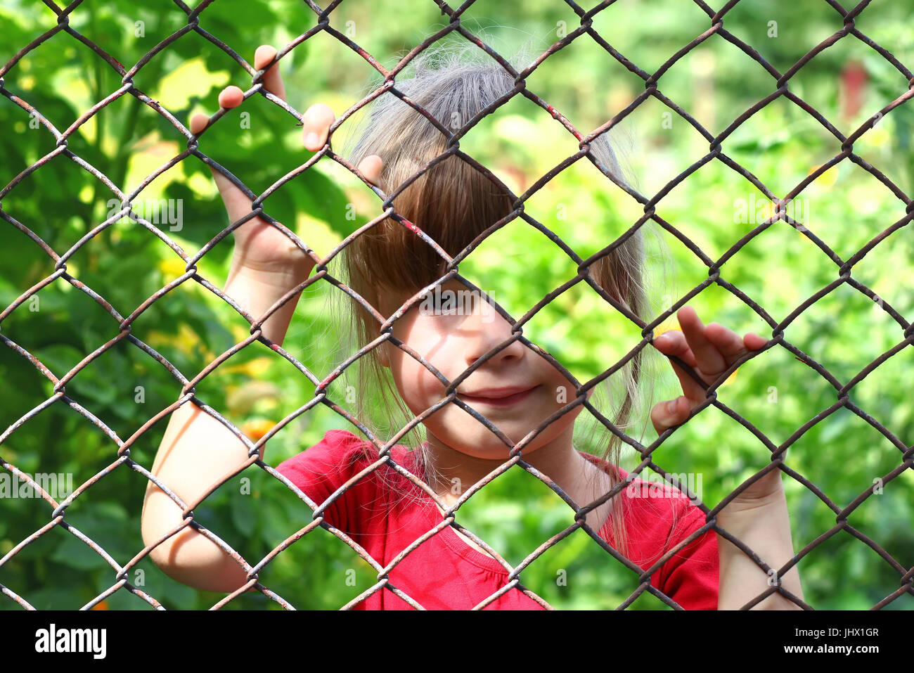 Abstract picture of a little girl behind chain link fence. Photo combination concept Stock Photo